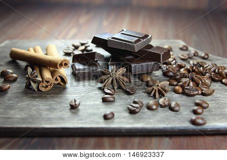 coffee, chocolate, cinnamon and anisetree on a wooden background