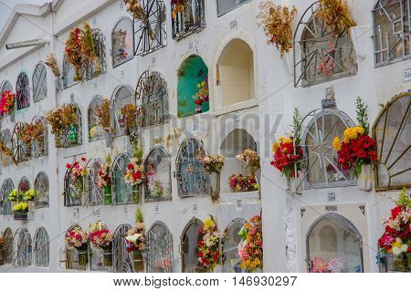 TULCAN, ECUADOR - JULY 3, 2016: vertical graves with some flowers at the side of each one.