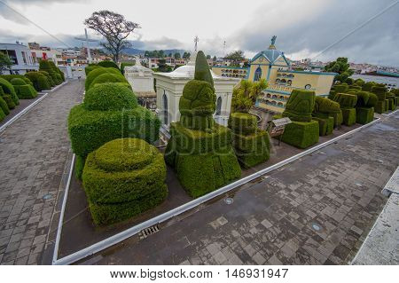 TULCAN, ECUADOR - JULY 3, 2016: overview of the cemetery with the city buildings as background.