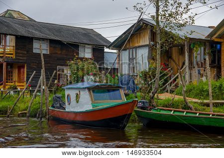 PASTO, COLOMBIA - JULY 3, 2016: small boat parked infront of some colorfull houses in la cocha lake.