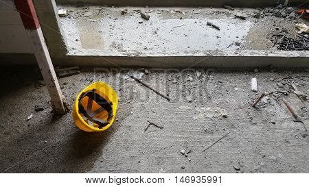 yellow safety helmet hard hat on the dirty floor at construction site