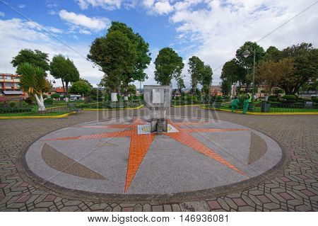 TULCAN, ECUADOR - JULY 3, 2016: sunclock located in the middle of a park with some trees as background.