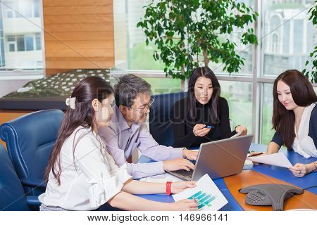 Business meeting Asian people sitting for table with business plan on high floor in the office. business people negotiate