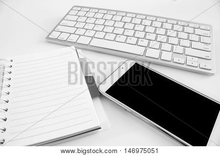 office table with notebook, computer keyboard and smartphone. copy space