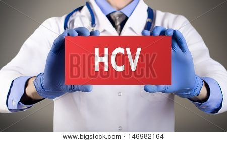 Doctor's hands in blue gloves shows the word HCV (hepatitis C virus). Medical concept.