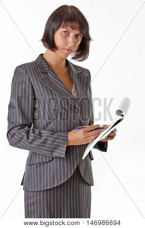 beautiful business woman wrote in a notebook and looks at camera