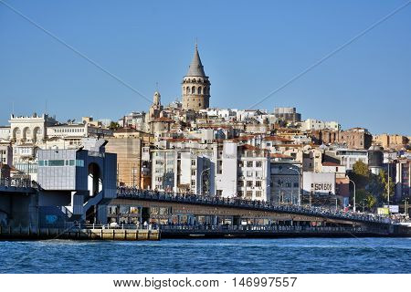 Istanbul, Turkey - November 3, 2015. Galata skyline in Istanbul, with Galata bridge, Galata tower, residential and commercial buildings and people.