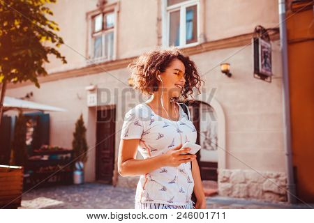 Beautiful Young Girl Using Smart Phone And Listening To The Music Walking On Street. Happy Woman Dan