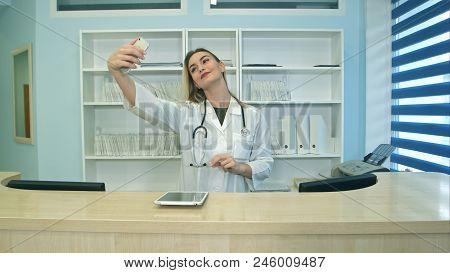 Smiling Female Medical Worker Taking Selfies With Her Phone At