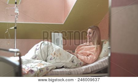 Young Woman Using Laptop Having Video Chat On Hospital Bed