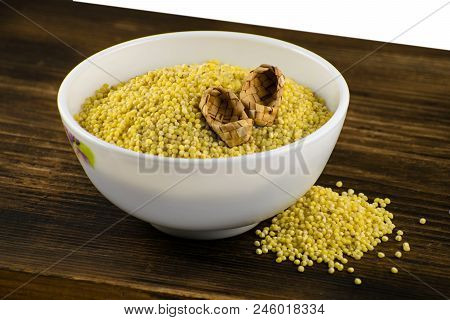 Millet In White Bowl On Brown Board. Wheat. Healthy Dietary Groats Background.