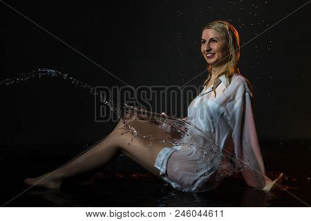 Nice Girl In The White Shirt And Water Drops Behind And Arround Her Illuminated By Light During A Ph