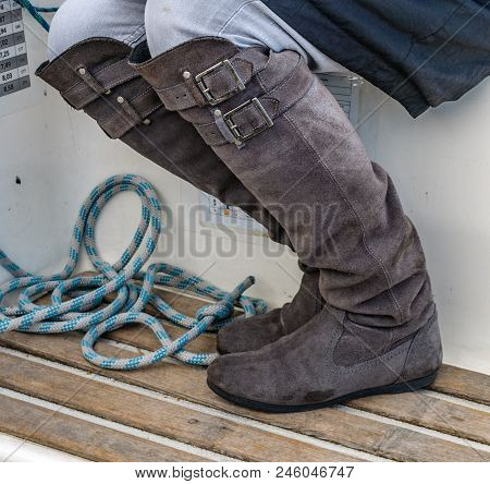 Grey Boots On A Sailboat And A Rope On Deck