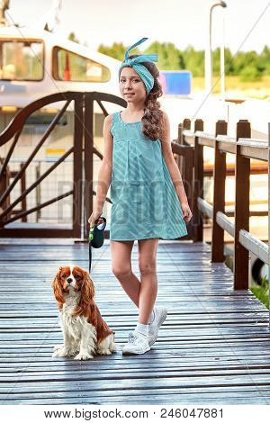 Elegant Child Near Puppy Breed Cocker Spaniel,charles King.beautiful Young Girl Stands Bridge Pier. 