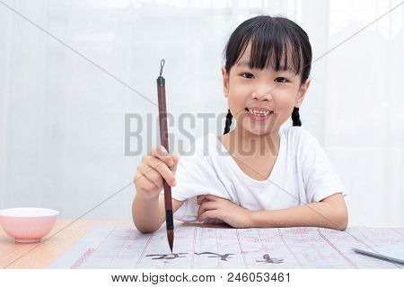 Asian Little Chinese Girl Practice Chinese Calligraphy At Home