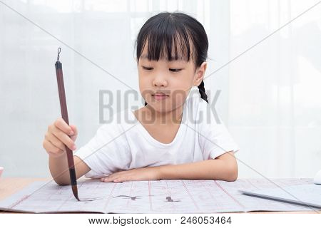 Asian Little Chinese Girl Practice Chinese Calligraphy At Home