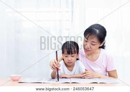 Asian Chinese Mother Teaching Daughter Practice Chinese Calligraphy At Home