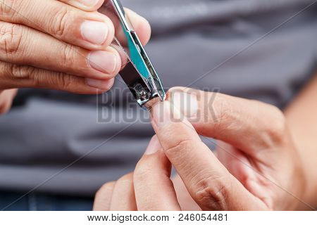Man Cutting Fingernails With A Nail Clipper