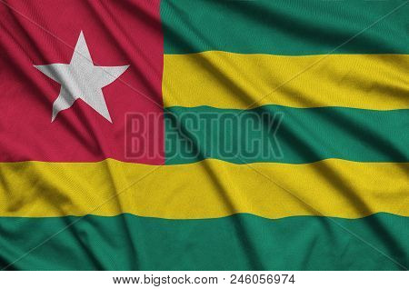 Togo Flag  Is Depicted On A Sports Cloth Fabric With Many Folds. Sport Team Waving Banner