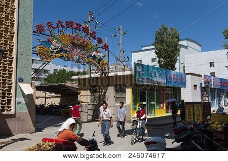 Dunhuang, China - August 7, 2012: Street Scene In The City Of Dunhuang, With People Walking In A Str