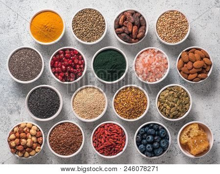 Various Superfoods In Smal Bowl Gray Concrete Background. Superfood As Chia, Spirulina, Raw Cocoa Be