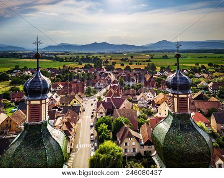 Soaring Majestic Church Saint Maurice In Little French Village Ebersmunster. Aerial Drone View.