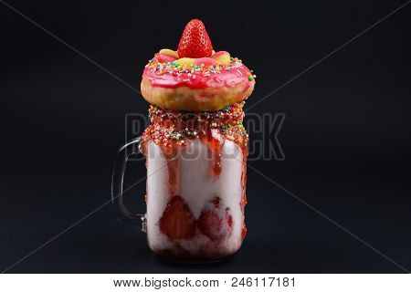 Freakshake. Extreme Milkshake With Strawberry, Jelly Sweets, Donut On Black Background.