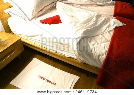 Double Bed Pulled Back With Ruffled Untidy Sheets With Red Hotwater Bottle Waiting.