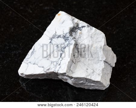 Macro Shooting Of Natural Rock Specimen - White Howlite Stone On Black Granite Background