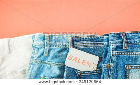 The Concept Of The Sale, Black Friday, A Discount With Blue Jeans On A Red Background With A Tag In 
