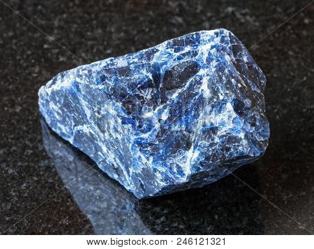 Macro Shooting Of Natural Rock Specimen - Raw Sodalite Gemstone On Black Granite Background