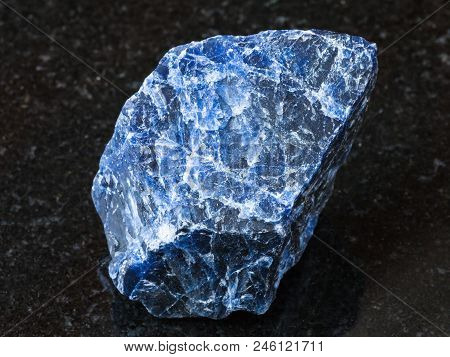 Macro Shooting Of Natural Rock Specimen - Rough Sodalite Gemstone On Black Granite Background