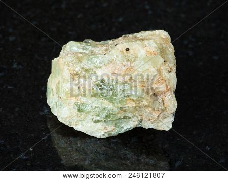 Macro Shooting Of Natural Mineral - Raw Chrysoberyl (green Beryl) Crystal On Black Granite From Ural