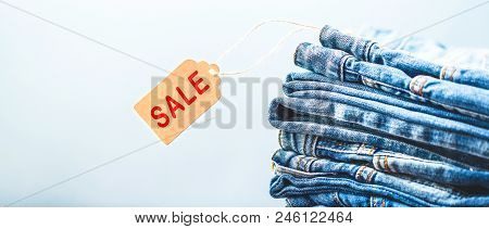 Sale, Discount, Black Friday Concept With Tag , Blue Jeans On A Light Background. Copyspace Banner R