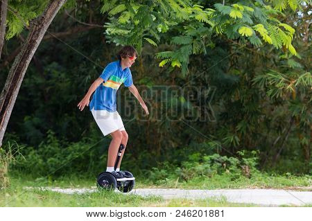 Child On Hover Board. Kids Riding Scooter In Summer Park. Balance Board For Children. Electric Self 
