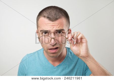 Wow Facial Emotion Concept. Surprised Young Man With Opened Mouth Touching Glasses. He Is Surprised 