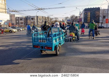 Beijing, China - March 10, 2016: People Are Driving Through The Streets With Bicycles, Scooters And 