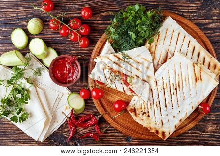 Grilled Flatbread Wraps Stuffed With Tomato And Zucchini Slices, Greens And Grated Mozzarella Cheese