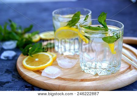 A Cool Drink, Sparkling Water With Lemon , Mint And Ice In Glasses On On A Wooden Board