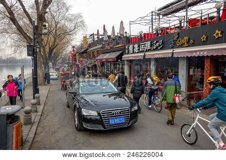 Beijing, China - March 12, 2016: People Are Driving Through The Streets With Bicycles, Scooters And 