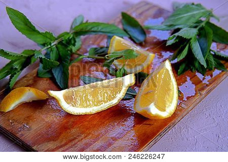 Ingredients For The Preparation Of Lemonade, Lemon Wedges And Mint Sprigs On A Wooden Board. Summer 