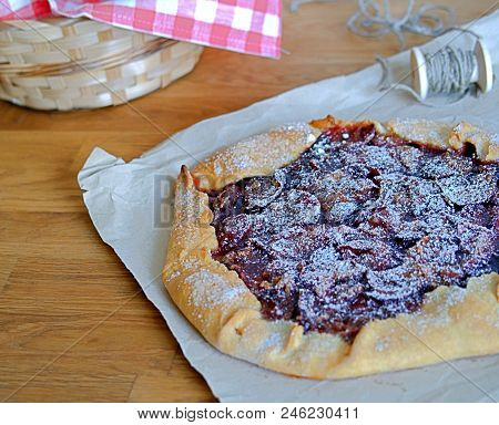 Open Pie-gallets From Fresh Dough With Plums And Cinnamon. Sprinkled With Powdered Sugar. Rustic Sty