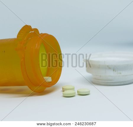 A Close Up Of Prescription Bottle On Its Side With Oxycodone Coming Out Of It With A White Backgroun