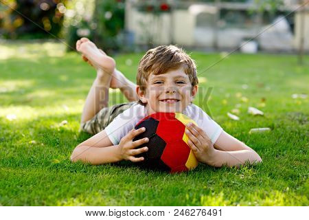 Happy Active Kid Boy Playing Soccer With Ball In German Flag Colors. Healthy Child Having Fun With F