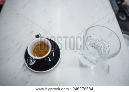 Coffee Mug And A Glass Of Water On A Table In A Coffee House