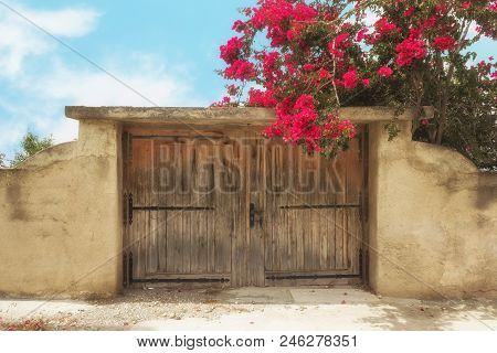 Ancient Wall And Traditional Wooden Gate On Salamina Island, Greece. Bright Sunny Day.
