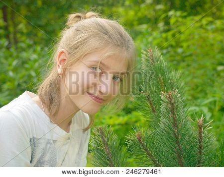 Teenege Girl With Golden Hair With A Nice Smile Posing In A Park