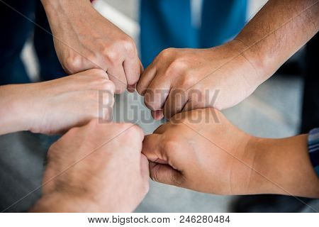 Close Up Top View Of Young People Doing Fist Bump By Hands Together. People And Business Concept. Un