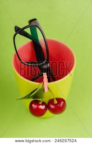 Fresh Cherries With Green Glass And Glasses On Green Background