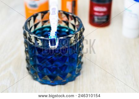 Oral Cleanser For Good Oral Health, Glass Of Mouthwash On A Table With Toothbrush And Toothpaste In 